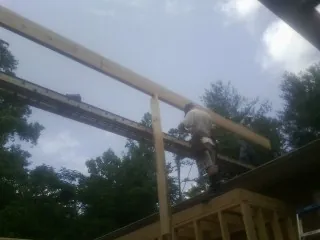 Carpenter setting a ridge beam over a new addition frame — Ice Dam Removal by Roofing Brothers in New Albin