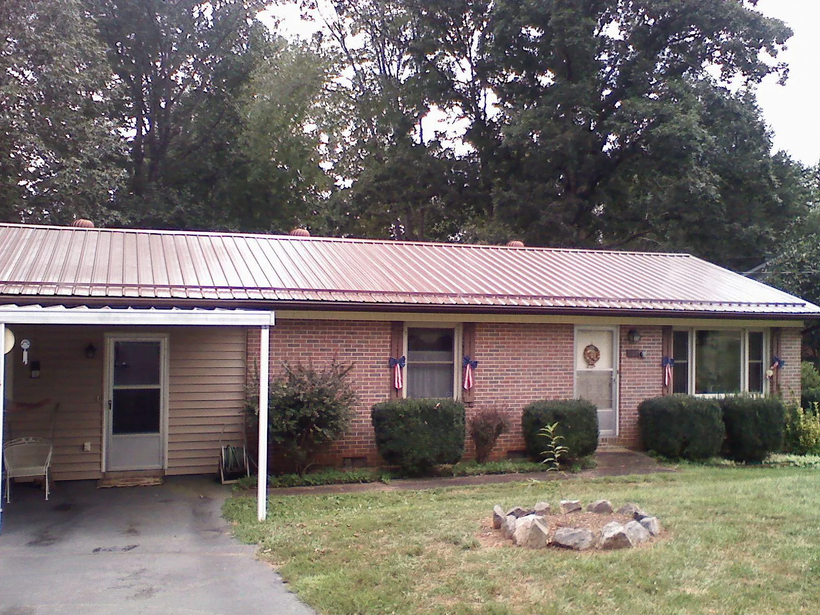 Bronze metal roof and carport on a brick ranch home — Roof Repair work by our crew in New Albin